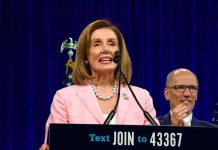 woman in pink blazer speaking at a podium