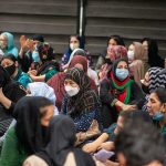 Group of women wearing face masks seated outdoors
