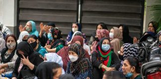 Group of women wearing face masks seated outdoors