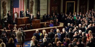 Legislators give a standing ovation in a grand chamber