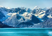 Snow-capped mountains with glaciers above a turquoise lake