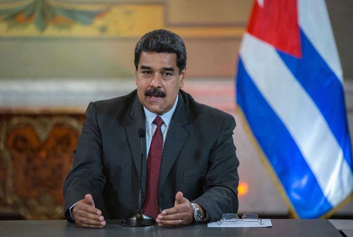 Nicolás Maduro speaking at a podium with a microphone