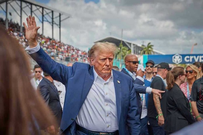 Donald Trump waving while walking through a crowded outdoor event