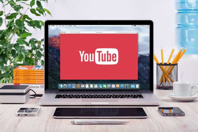 293731811-2 YouTube logo on a laptop screen on desk.