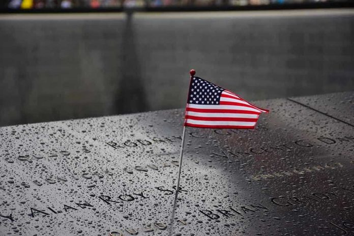 574569265 American flag on a rainy memorial nameplate.