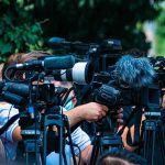 Trump Says Kim Jong Un Treats Him with ‘Great Respect’ TV news cameras crowding together at an outdoor event