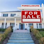 For sale sign in front of suburban house
