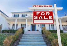 For sale sign in front of suburban house