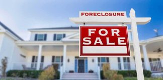For sale sign in front of suburban house