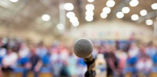 microphone on a podium facing a blurred audience