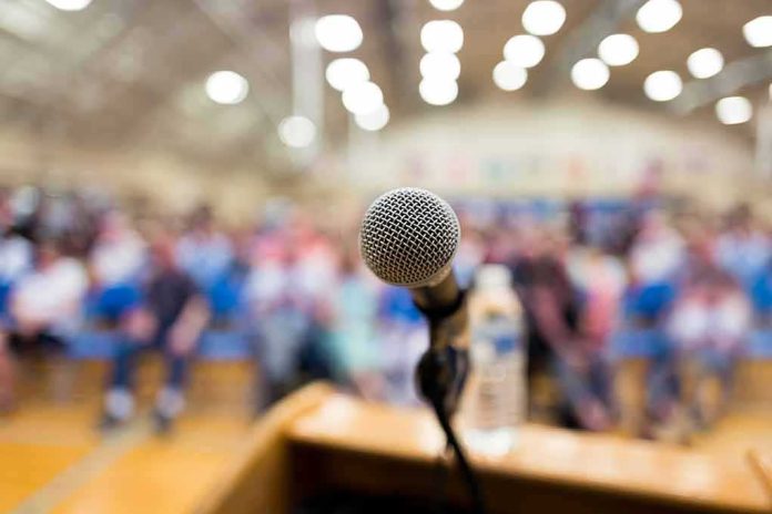 shutterstock_1111824998 microphone on a podium facing a blurred audience