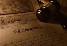 Gavel resting on U.S. Constitution and 5th Amendment document