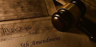 Gavel resting on U.S. Constitution and 5th Amendment document