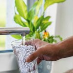 Alarming Claim About U.S. Drinking Water Gets Tested Hand filling a glass with water from a kitchen faucet