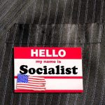 Socialist Label Becomes the Weapon Name tag on a pinstripe suit jacket pocket