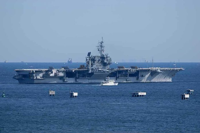 shutterstock_1314966416-2 Aircraft carrier at sea with small boat alongside