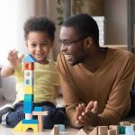 Lindsay Clancy Killed Her Kids ‘Out of Love’ Expert Says Father and child building a tall tower with colorful wooden blocks on the floor
