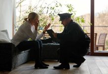 police officer speaking with distressed woman on a sofa