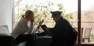 police officer speaking with distressed woman on a sofa