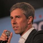 Reporter Asks Beto O’Rourke: ‘Is God Non-Binary?’ man speaking into a microphone on stage