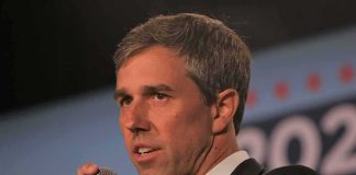 man speaking into a microphone on stage