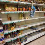 Kraft Heinz CEO Reveals SHOCKING Financial Strain Partially empty supermarket shelves with scattered canned goods