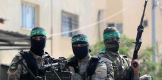 armed masked men in camouflage with green headbands