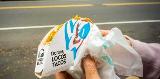 Hands holding a Taco Bell Doritos Locos Tacos