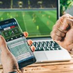 Gen Z’s Betting Boom Alarms Wall Street Person checking live soccer betting odds on a smartphone