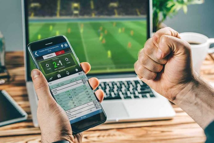 shutterstock_1570645063 Person checking live soccer betting odds on a smartphone