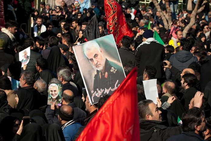 Qasem Soleimani posters held in a large crowd; Kate Beaton present among attendees