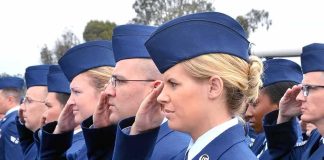 Uniformed service members saluting in formation