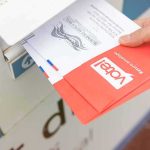 Supreme Court Blocks Trump on Midterm Mail-In Rules Hand dropping mail-in ballots into a drop box