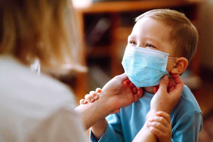 child wearing a surgical mask being adjusted by an adult