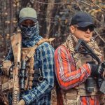 Mexican Cartels Say They Are NOT Scared of Trump Two armed individuals in tactical gear standing back to back in a forest
