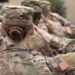 U.S. soldiers in camouflage uniforms saluting
