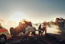 Firefighters at overturned car crash scene at sunset