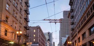 Urban street lined with mid-rise buildings at dusk