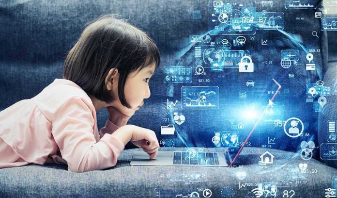 Child lying on couch using a laptop with digital icons overlay