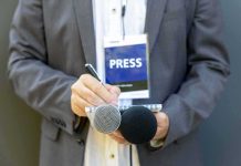 Journalist holding notebook and microphones