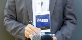 Journalist holding notebook and microphones