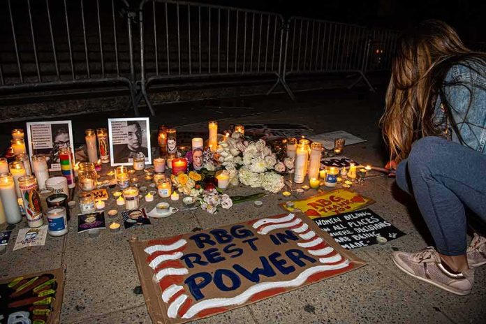 Vigil with candles and signs on a sidewalk at night