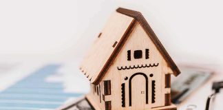Fed HIKES Rates for First Time Since 2023 Wooden house model on money and contract papers
