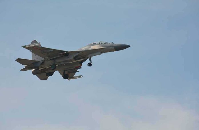 shutterstock_1929618212 Military fighter jet in flight with landing gear down