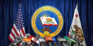 Press microphones at a podium before California governor seal