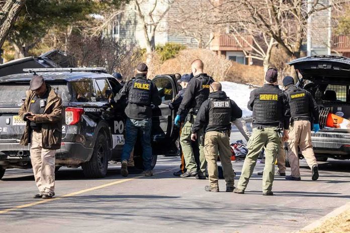 shutterstock_2126536382-2 Police and sheriff officers gather around vehicles on a suburban street
