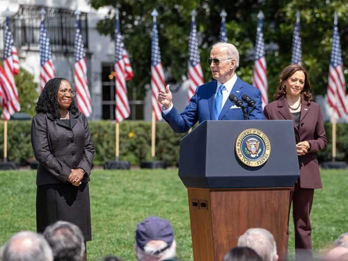 Joe Biden speaking at a podium outdoors with Kamala Harris standing nearby