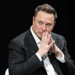 Elon Musk Joins AI Slowdown! man in a suit with hands clasped thoughtfully
