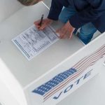 Voter filling out a ballot in a private voting booth