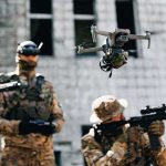 New Army Truck Can Hunt Drones WITHOUT a Driver Quadcopter drone flying above soldiers in camouflage